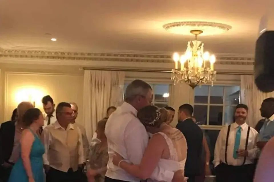 Guests dancing under a chandelier at a wedding reception